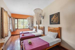 a bedroom with two beds and a window at Surjios Guest House in Jinja +28 photos