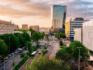 a city street with cars and buses in a city at Sky Suite 22 Hanza Tower in Szczecin