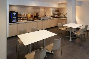 a restaurant with tables and chairs and a kitchen at City Express by Marriott Ciudad Victoria in Ciudad Victoria