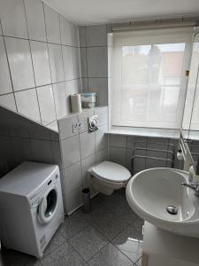a bathroom with a washing machine and a sink at Apartment to Düsseldorf - near Airport DUS - Trade Fair - Arena in Düsseldorf +5 photos