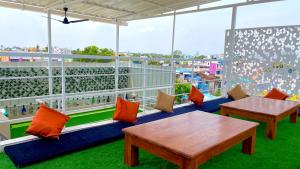 a patio with two tables and chairs on a roof at BUNK HUB hostel in Pondicherry