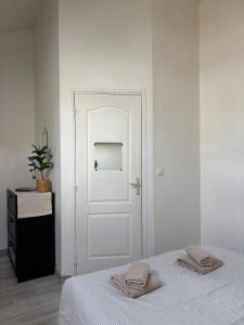 a bedroom with a white door with two towels on a bed at L'Aile de Fontainebleau in Fontainebleau