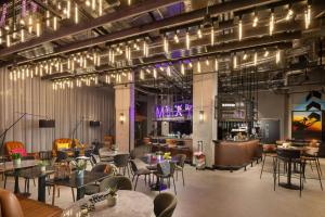 a restaurant with tables and chairs and a bar at Moxy Dublin Docklands in Dublin
