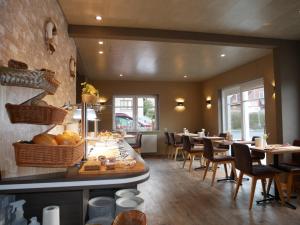a dining room with tables and chairs in a restaurant at Hotel Thule in Carolinensiel