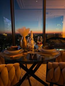 a table with wine glasses and a view of a city at Sky Suite 22 Hanza Tower in Szczecin +34 photos