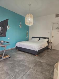 a bedroom with a bed and a blue wall at Studio Caroline in Eilat