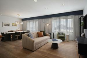 a living room with a couch and a dining room at The Alexander, Autograph Collection in Indianapolis