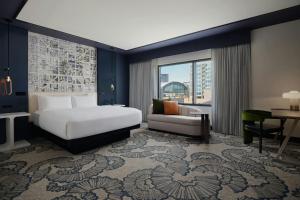 a hotel room with a bed and a couch at The Alexander, Autograph Collection in Indianapolis +27 photos