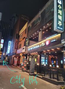 a city at night with a sign on a building at Star Guest House in Seoul