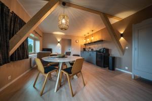 a kitchen and dining room with a table and chairs at By de barte in Beers