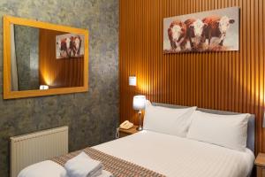 a hotel room with a bed and two cows on the wall at Grampian Hotel in Perth +54 photos