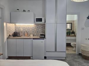 a white kitchen with a sink and a refrigerator at Studio Caroline in Eilat