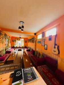 a room with couches and guitars on the wall at Non Stop Cafe Hostel & Stay in Manāli