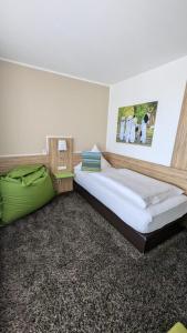 ein Schlafzimmer mit einem großen Bett und einem grünen Sofa in der Unterkunft Hotel Scheidberg Wallerfangen bei Saarlouis in Wallerfangen + 49 Fotos