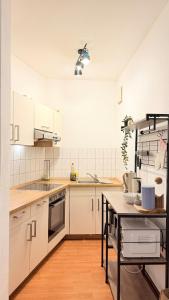 a kitchen with white cabinets and a wooden floor at Apartment in Leipzig in Leipzig