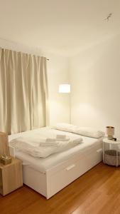 a white bed in a room with a window at Apartment in Leipzig in Leipzig