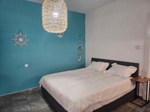 a bedroom with a bed with a blue wall at Studio Caroline in Eilat