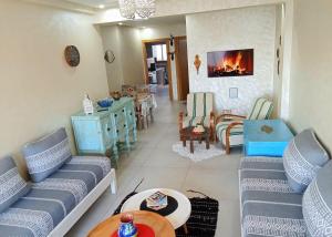 a living room with couches and a table and a fireplace at sunny amazigh apt avev piscine pool steps from beach 2balcony 2smartTV pool in Essaouira