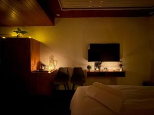a hotel room with a bed and a flat screen tv at Misty Garden Retreat in Nandigunda