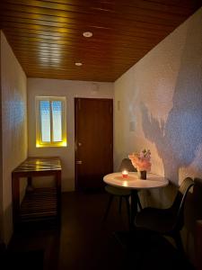 a room with a table and a window and a table with a candle at Misty Garden Retreat in Nandigunda
