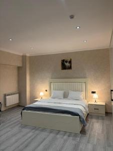 a bedroom with a large bed with two tables and two lamps at Grand Teatro Hotel in Ganja +18 photos