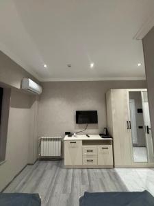 a living room with a tv on the wall at Grand Teatro Hotel in Ganja
