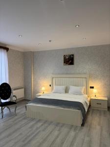 a bedroom with a large bed and a chair at Grand Teatro Hotel in Ganja