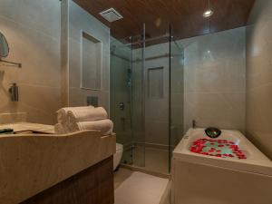 a bathroom with a shower and a bath tub with a sink at The Harmukh Hills in Batakūt +39 photos