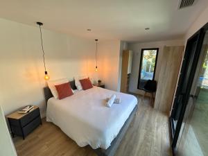 a bedroom with a large white bed and a window at Villa bord de mer in Labenne +25 photos
