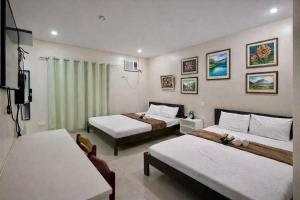 a hotel room with two beds and a television at Zolaria Hotel and Restaurant in Tagaytay +10 photos