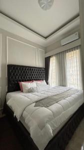 a bedroom with a large bed with a black headboard at Villa Bali Rice Field in Sukaraja +15 photos