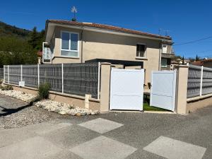 a house with two gates in front of a fence at Chez Val et Phil in La Voulte-sur-Rhône