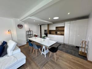 a kitchen and living room with a white table and chairs at Villa bord de mer in Labenne