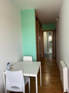 a white table and two white chairs in a room at Albergue Alfonso II in Melide
