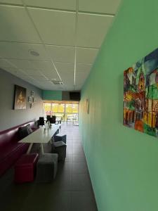 a room with a table and chairs and a painting on the wall at Albergue Alfonso II in Melide