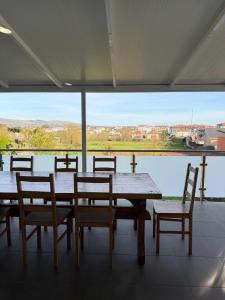 a table and chairs with a view of the water at Albergue Alfonso II in Melide