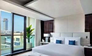 a bedroom with a white bed and a large window at Villa Alfa Kosta in Cairo