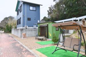 a house with a green and blue house at シーサイド興津 in Sanuki