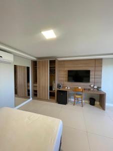 a bedroom with a bed and a desk and a television at Paraiso Beach Hotel in Aquiraz