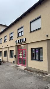 a building with a red door in a parking lot at Motel Haid in Linz +6 photos