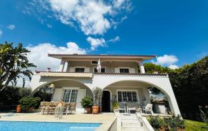 a house with a pool in front of it at Villa Eleni in Lagonissi