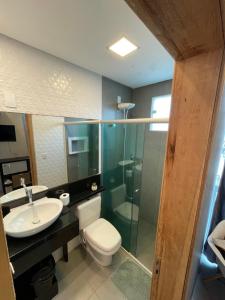 a bathroom with a toilet and a sink and a shower at Studio compacto em Camboriú in Camboriú