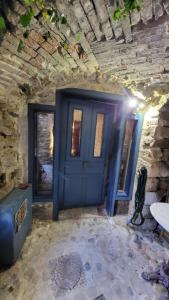 a blue door in a stone building with a table at La chambre secrète in Aiguèze