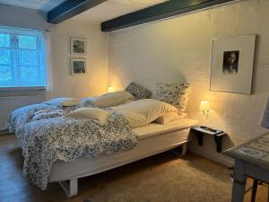 a bedroom with a bed and a wall with a window at pallisgaard B&B in Struer