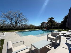 a swimming pool with two chairs and a table and chairs at Villa Monaco in Mosciano SantʼAngelo