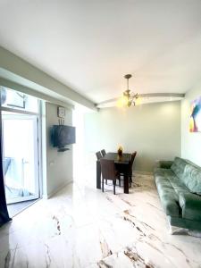 a living room with a green couch and a table at Apartamenti Panorama in Kobuleti