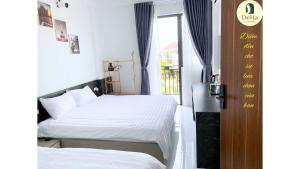 a hotel room with two beds and a window at DeHa Homestay in Hue