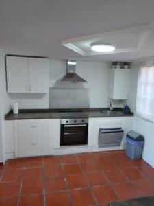 a kitchen with white cabinets and a stove top oven at A Casa Do Viso Do Chirin in Ponteareas +10 photos