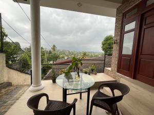 a glass table and chairs on a balcony at Cottage Fifty One in Kandy