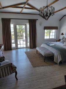 a large bedroom with a bed and a chandelier at De Molen Guest House in Somerset West +120 photos